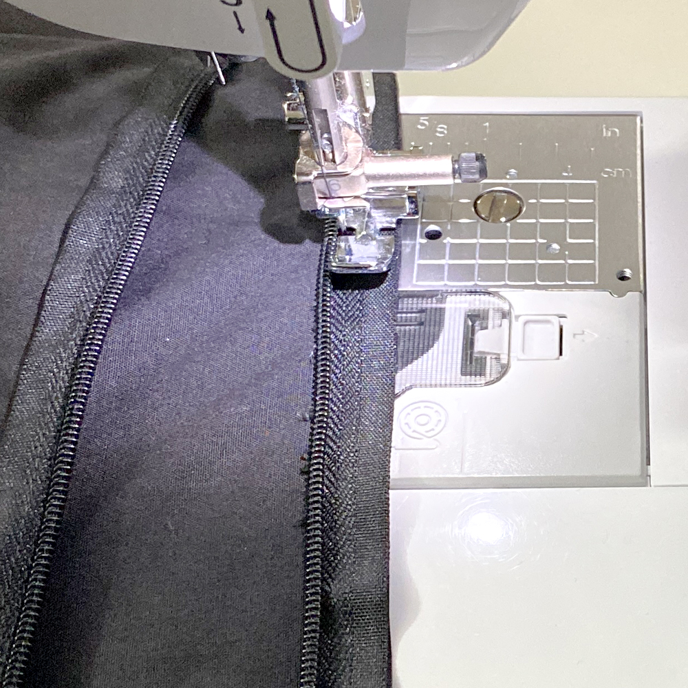 Sew very close to zipper